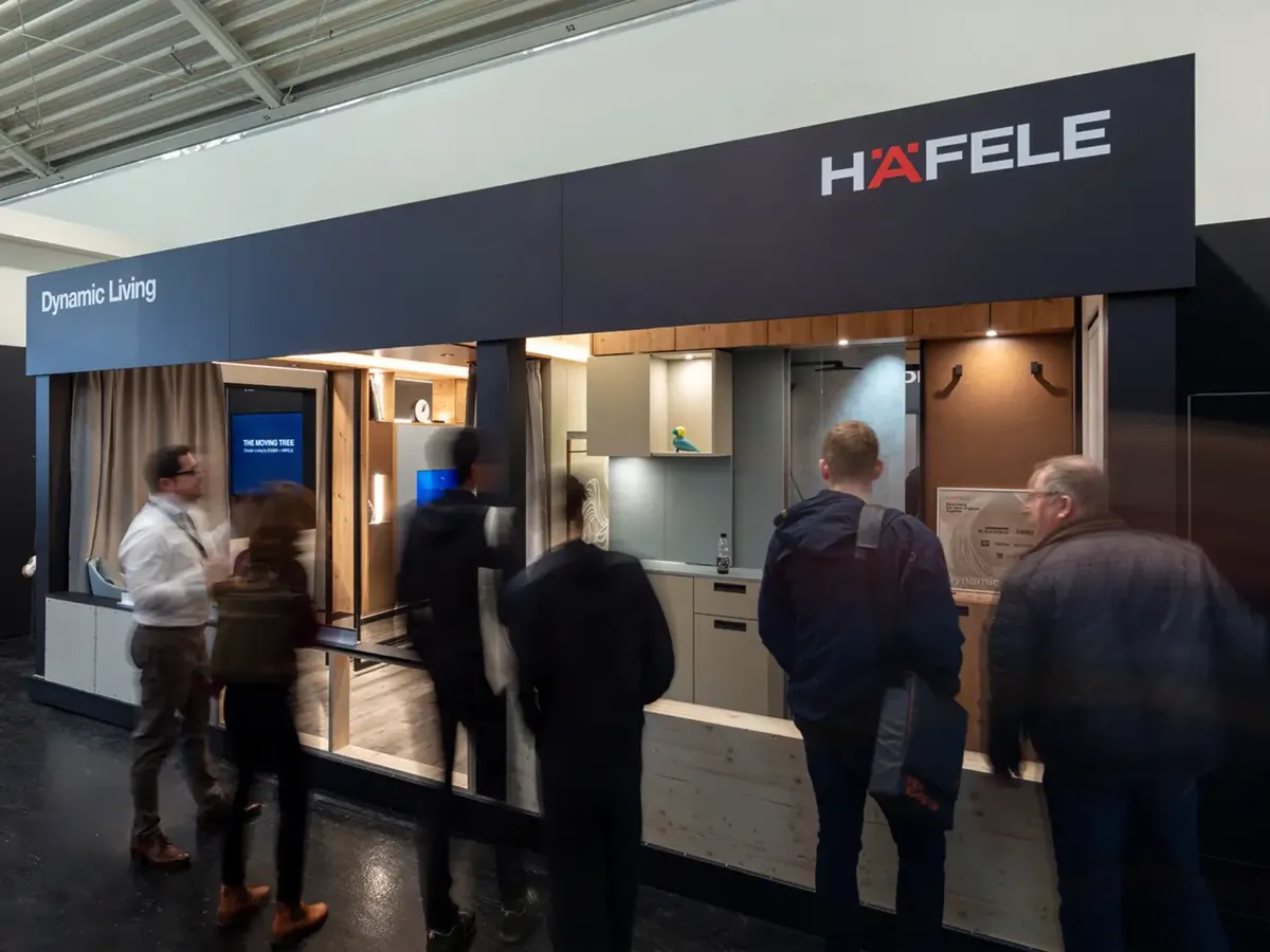 Visitors looking at an interactive presentation of Häfele’s »Dynamic Living« concept with a digital product demonstration at BAU 2025
