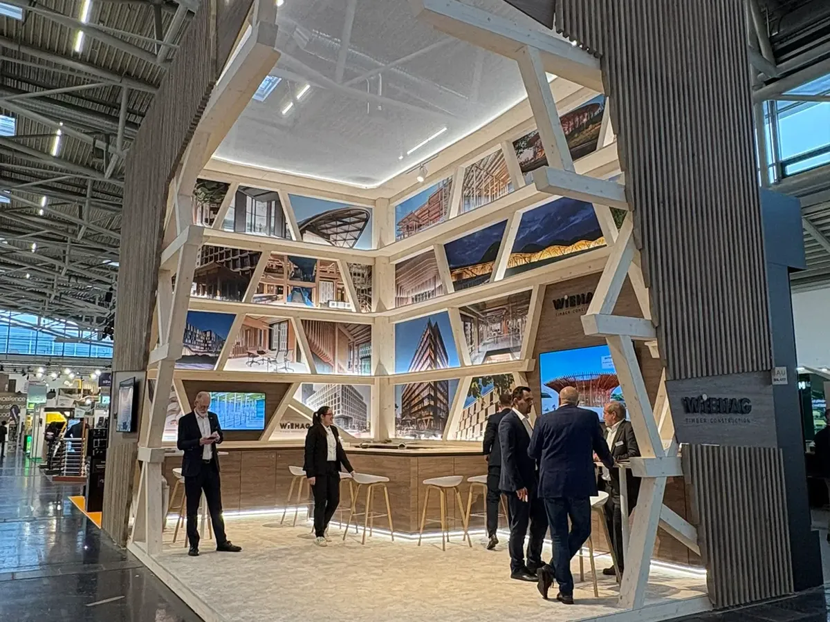 WIEHAG timber structure with a torn-open corner as the entrance area, integrated picture gallery with reference projects arranged in triangles