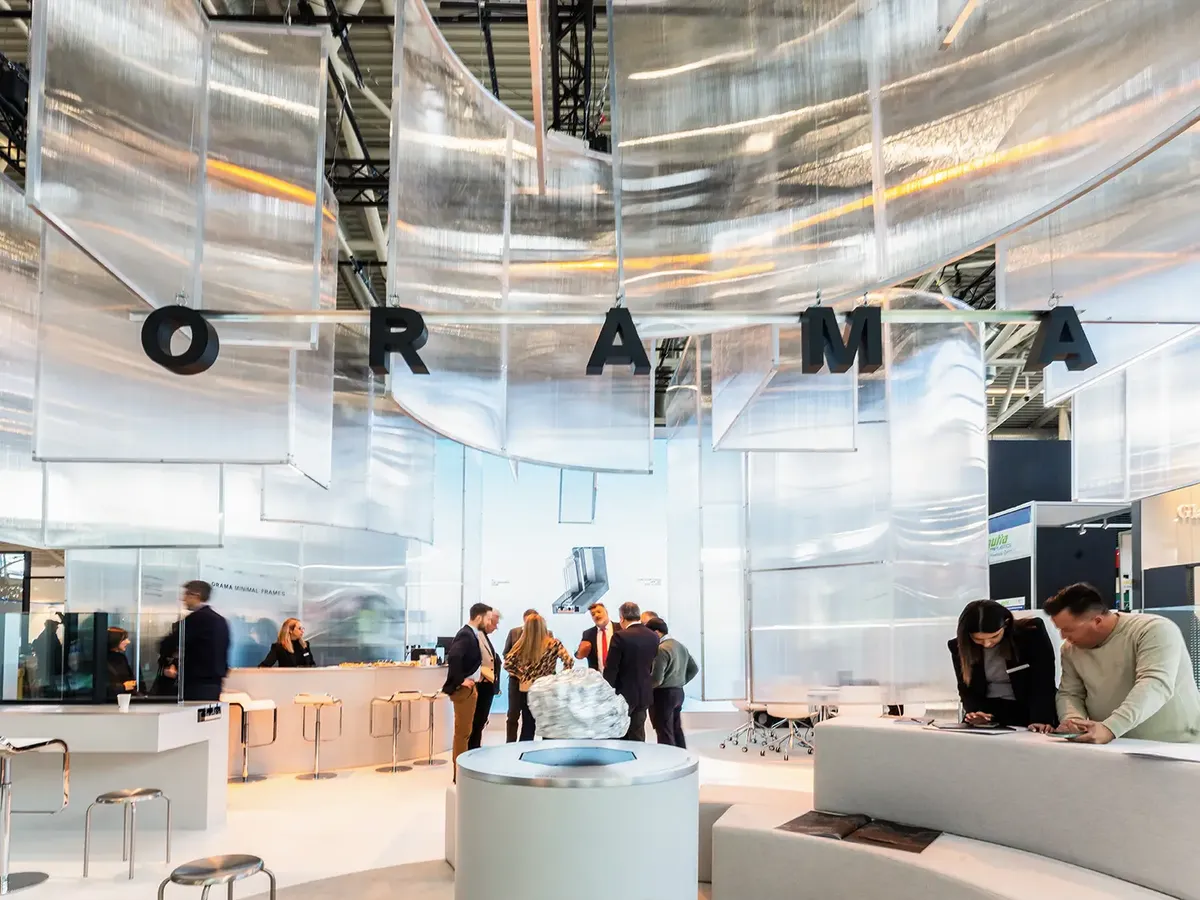 Orama’s translucent stand with a floating installation of the company name, a minimalist product presentation of frameless window and door systems