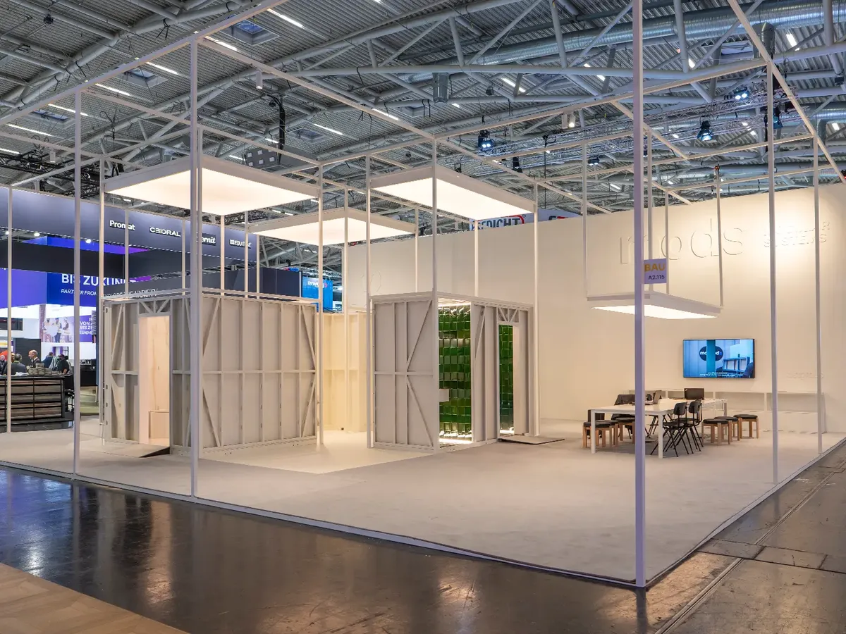 MODS stand with modular bathroom pods in cream white, contrasting with Portuguese tiles and laboratory-like light boxes