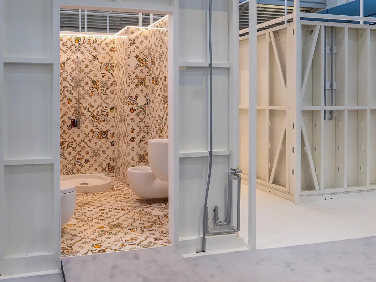 MODS bathroom pod at BAU 2025: a bathroom with ornamental tiles in beige and white, modern sanitaryware in a minimalist design