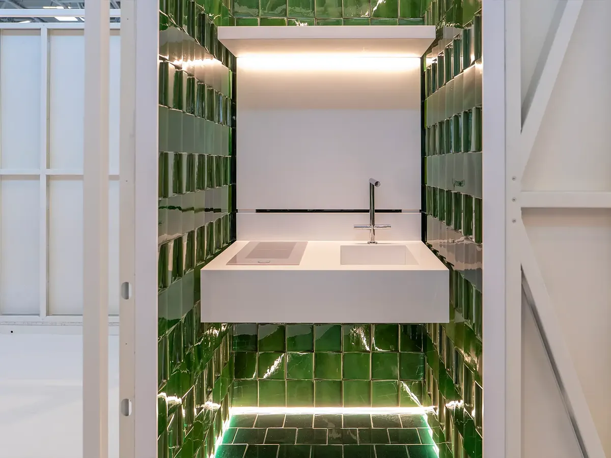 MODS bathroom pod: a minimalist washbasin surrounded by green glazed wall tiles with atmospheric LED lighting